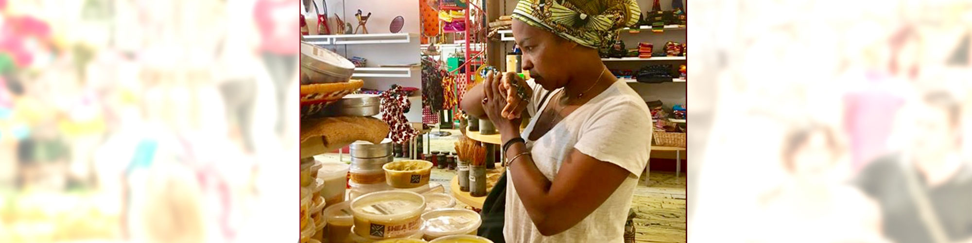 Customer at Arts Africains Store enjoying assorted scents of shea butter